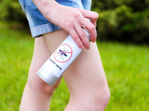 bambino spruzza il repellente per zanzare sulle gambe